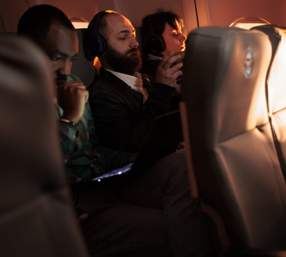 Diverse passengers flying in economy class with airplane jet, using international airways service on commercial flight. Group of people travelling by plane to go to holiday destination or job trip.